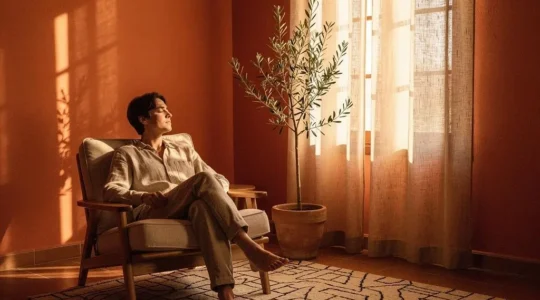 Persona relajada en un salón luminoso de estilo mediterráneo español que transmite calma y bienestar emocional