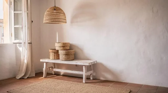 Rincón de un salón mediterráneo español decorado con cestas, lámparas y textiles de fibras naturales tejidas a mano