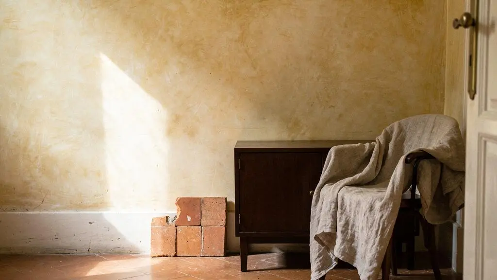 Composición editorial de una paleta cromática de cinco colores integrada en una vivienda española luminosa, con materiales naturales y luz mediterránea