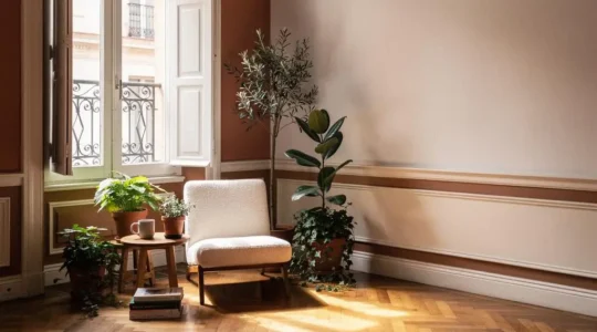 Rincón luminoso de un piso español junto a una ventana, transformado de espacio vacío en zona funcional de lectura